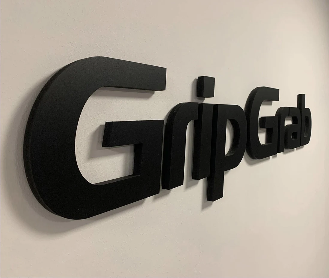 Sorte, fritstående logobogstaver med navnet GripGrab monteret på en lys væg